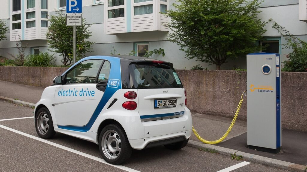 A small electric car plugged into a public charging point