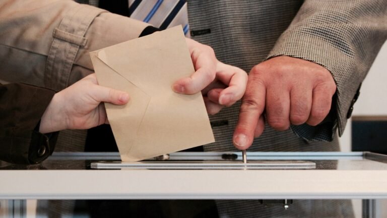 A voter placing a completed ballot paper into a ballot box