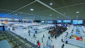 Passengers moving through a busy airport departures hall