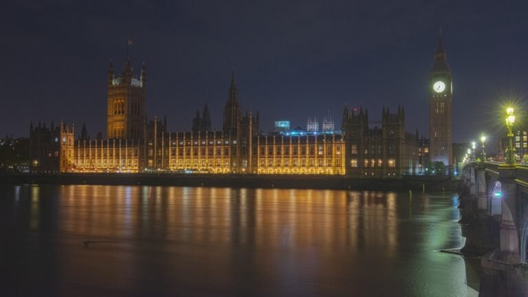 The Houses of Parliament and Big Ben lit up beside the Thames at night