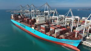 A container ship being loaded at a busy port terminal