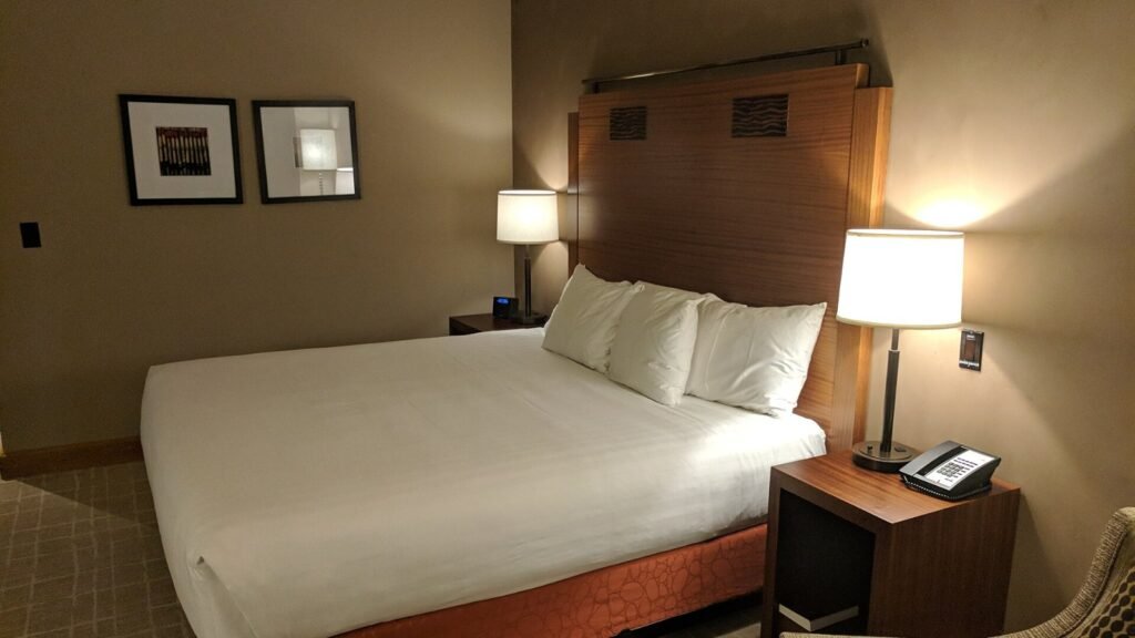 A neatly made bed in a quiet, softly lit bedroom
