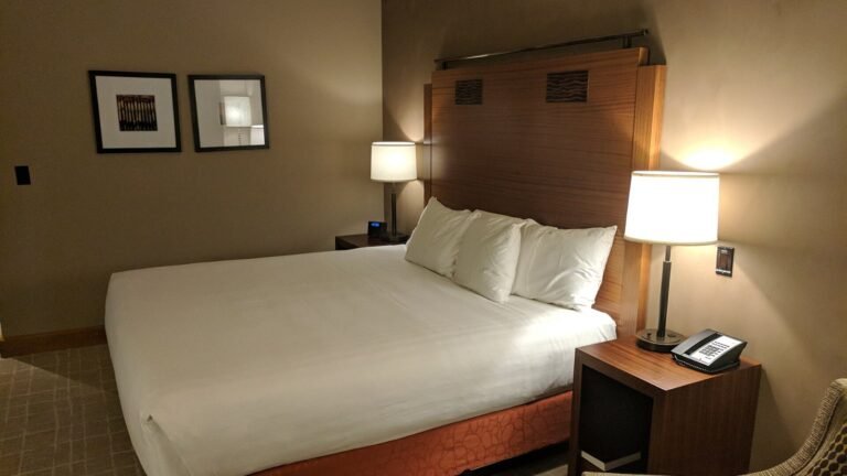 A neatly made bed in a quiet, softly lit bedroom