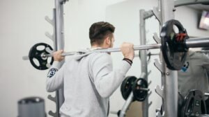 A person lifting a loaded barbell in a gym