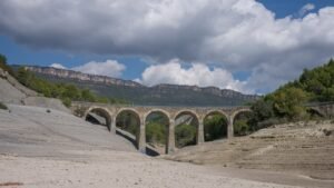 A reservoir reduced to bare rock and low water during drought