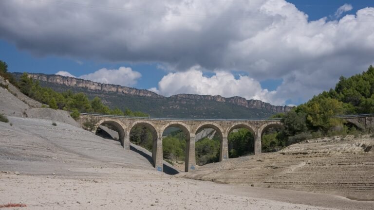 A reservoir reduced to bare rock and low water during drought