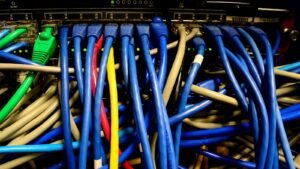 A dense bundle of coloured network cables in a server rack