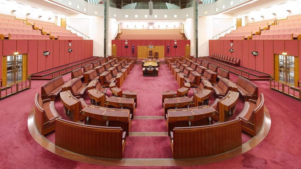 An empty parliamentary debating chamber with rows of benches